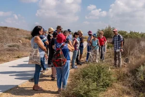 קבוצת מטיילים פנויים פנויות מקשיבים להסבר של מדריך במסלול טבע