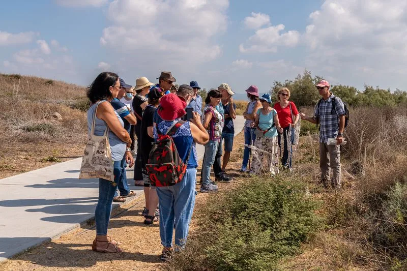 קבוצת מטיילים פנויים פנויות מקשיבים להסבר של מדריך במסלול טבע